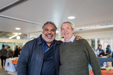 Two men face the camera smiling at the Aboriginal Housing Forum