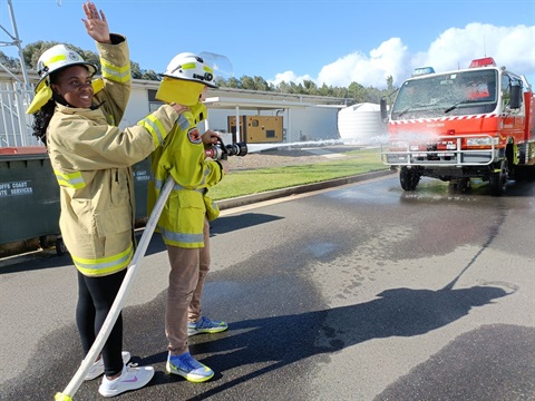 Two teenagers attending First Responder Fundamentals Workshop operating a fire hose